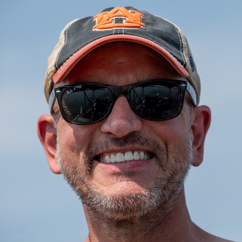 Brian Watson smiling in a ball cap and sunglasses